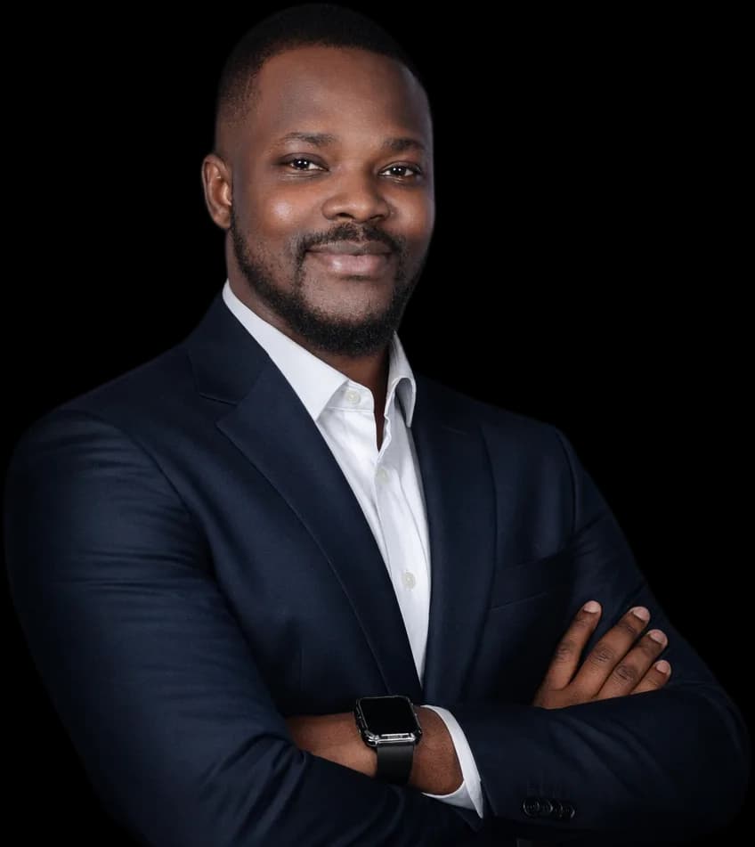 Portrait de Rachid Ouedraogo en costume bleu marine, bras croisés, souriant